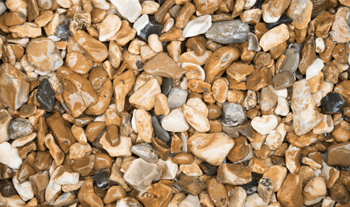 Shingle, a natural flint aggregate, graded from 10mm to 20mm, displayed wet.