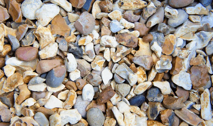 Loose display of golden shingle, containing golden, brown and white flints, graded from 10 to 20mm, showcased dry.