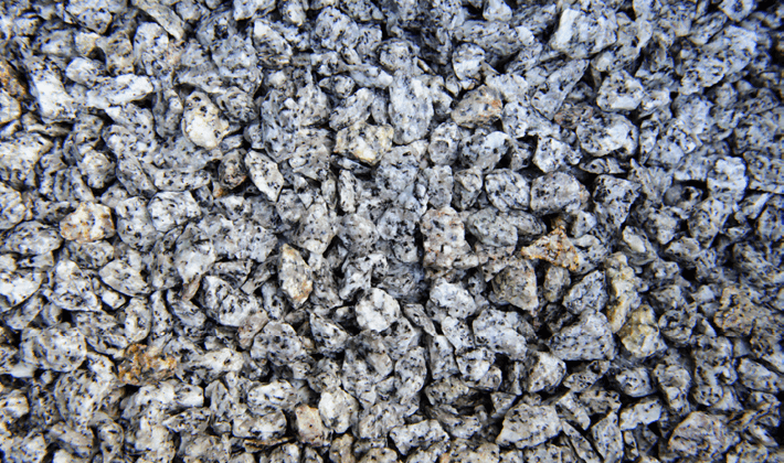 Loose display of silver grey chippings, graded from 6mm to 14mm, containing black, silver and quartz chippings, showcased wet.