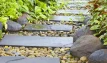 Multi-coloured, naturally rounded cobbles, showcased as ground cover around stepping stones.