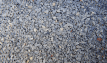 Permeable paving aggregate containing pink and grey angular limestone and granite, displayed loose.