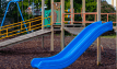 Loose display of reddish-brown play bark chippings, showcased around play equipment.