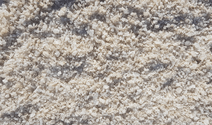 White de-icing salt, also known as grit or road salt, displayed loose.