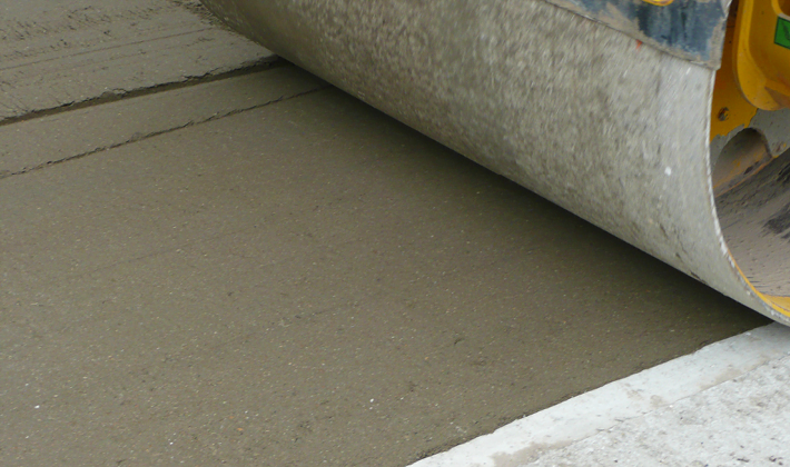 Cement/hydraulically bound granular mixture (CBGM/HBM), being laid with a road roller.